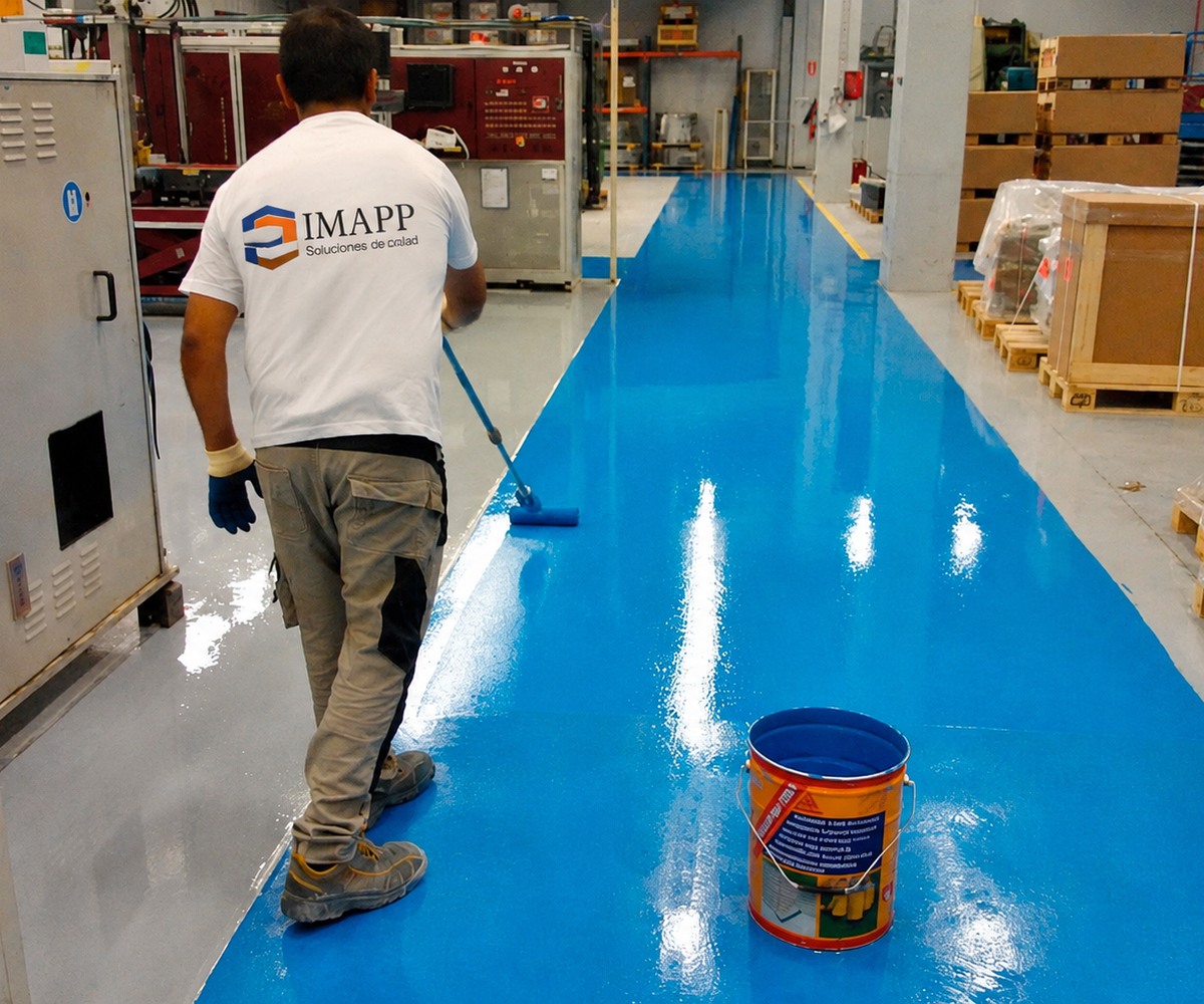 Aplicación de pintura epóxica azul en piso industrial